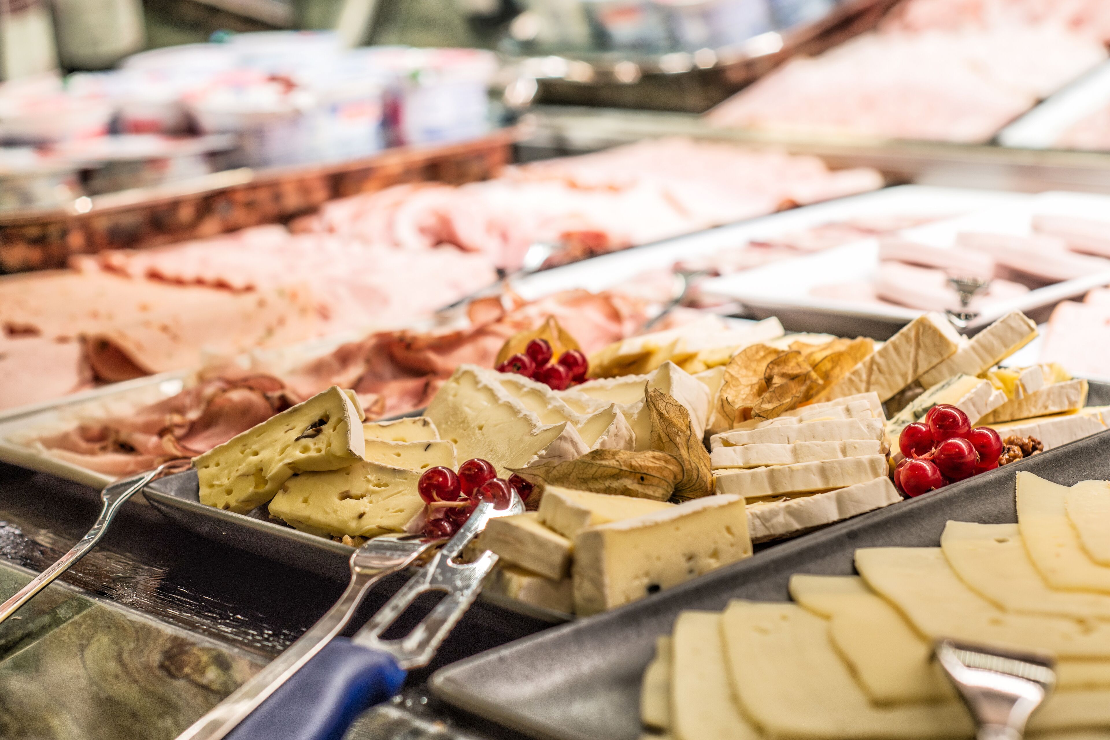 A cheese and fruit display with various types of cheese and fruits.