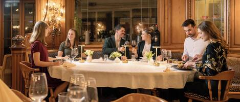 Un coin repas avec une table ronde, des chaises en bois et un lustre.