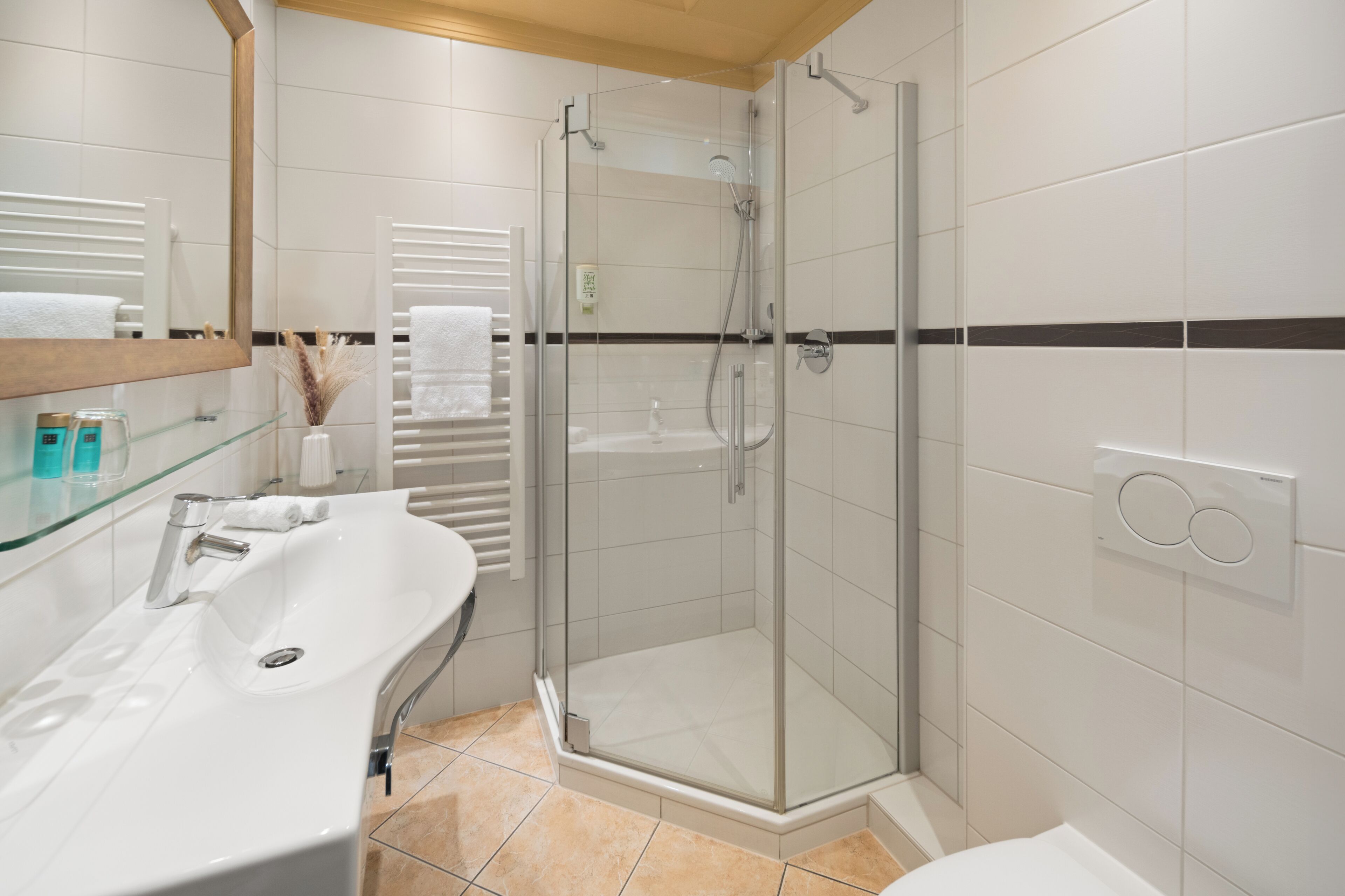A modern bathroom with a glass-enclosed shower, a white sink, and a mirror.