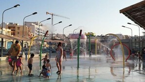 A water play area with multiple water jets and slides, surrounded by urban buildings. - For Rest Aparthotel (St. Paul's Bay)