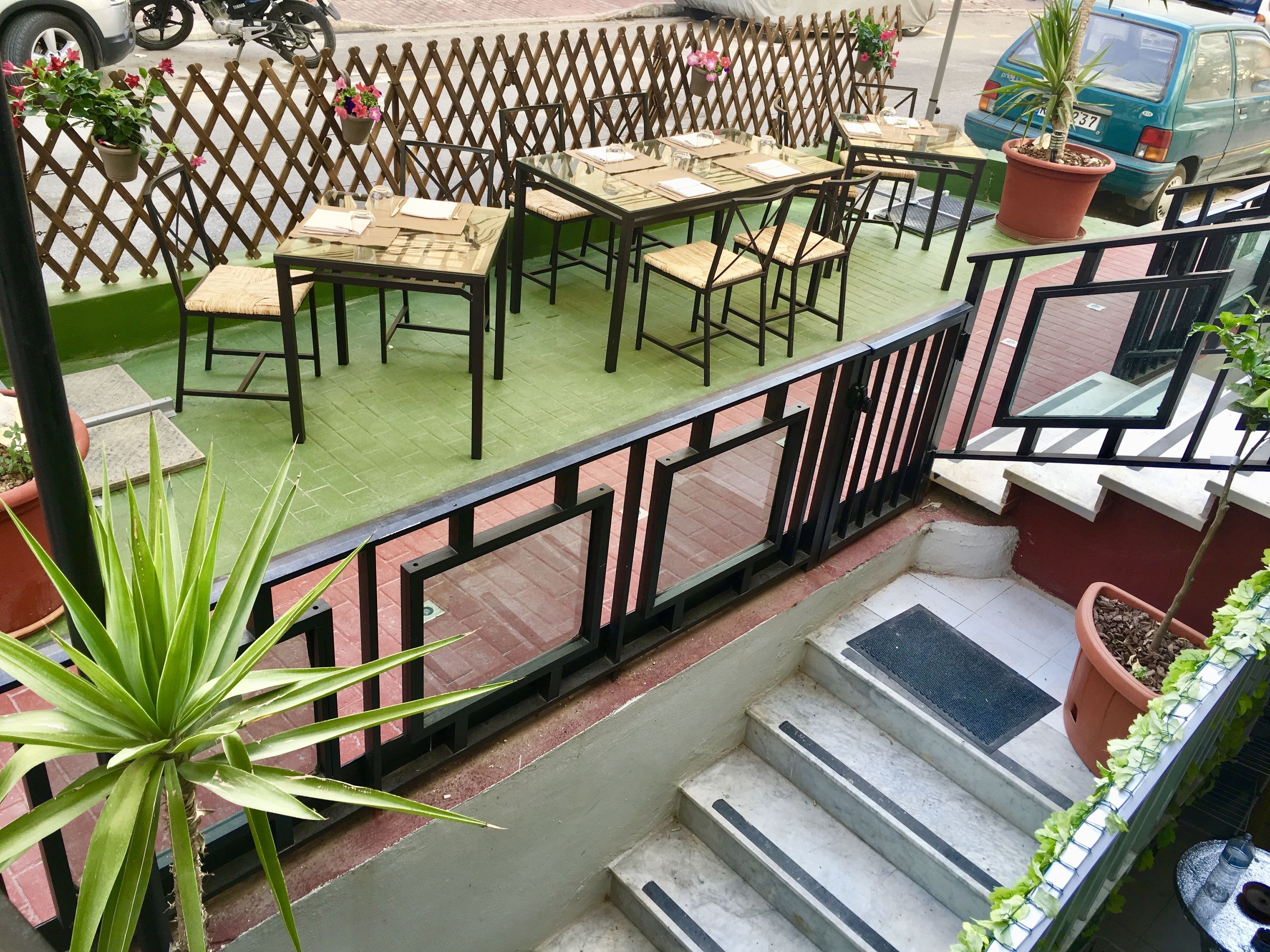 A terrace with outdoor seating, a wooden fence, and potted plants.