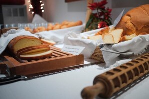 A buffet setup with bread, cheese, and a rolling pin. - Martinella (Folgaria)