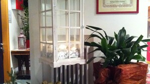 A room with a white lantern, a framed certificate on the wall, and a potted plant with a bow. - Martinella (Folgaria)