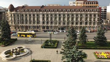 Un edificio grande con un patio central, rodeado de árboles y un jardín de flores.