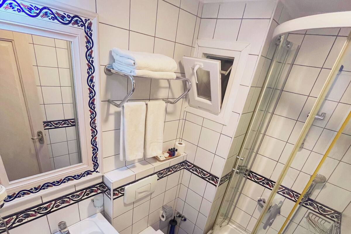 A bathroom with two sinks, a toilet, and a glass-enclosed shower.