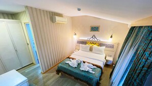 Een hotelkamer met een bed, nachtkastje en een kledingkast.