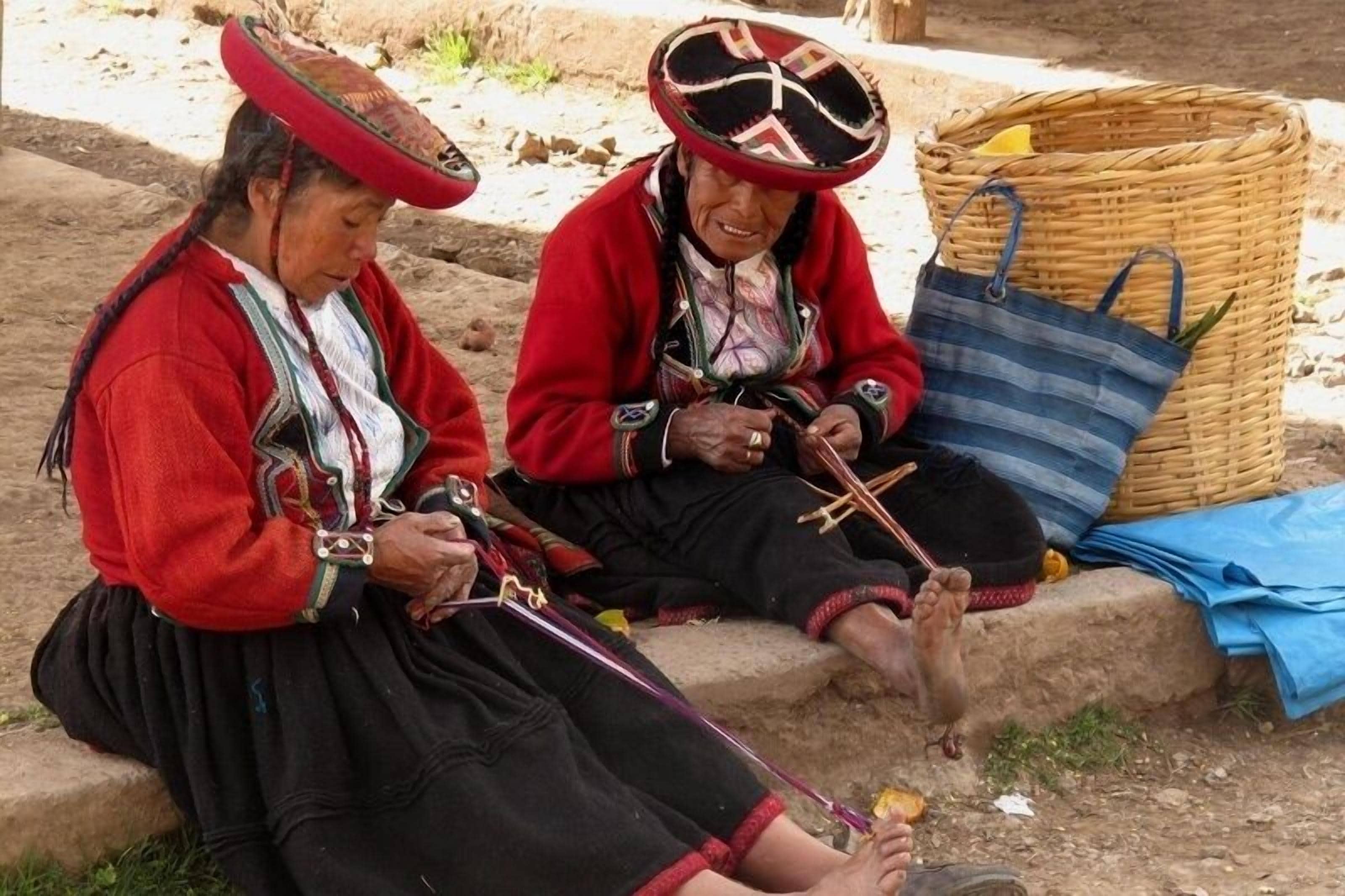 Dos personas sentadas al aire libre, realizando una actividad con herramientas.