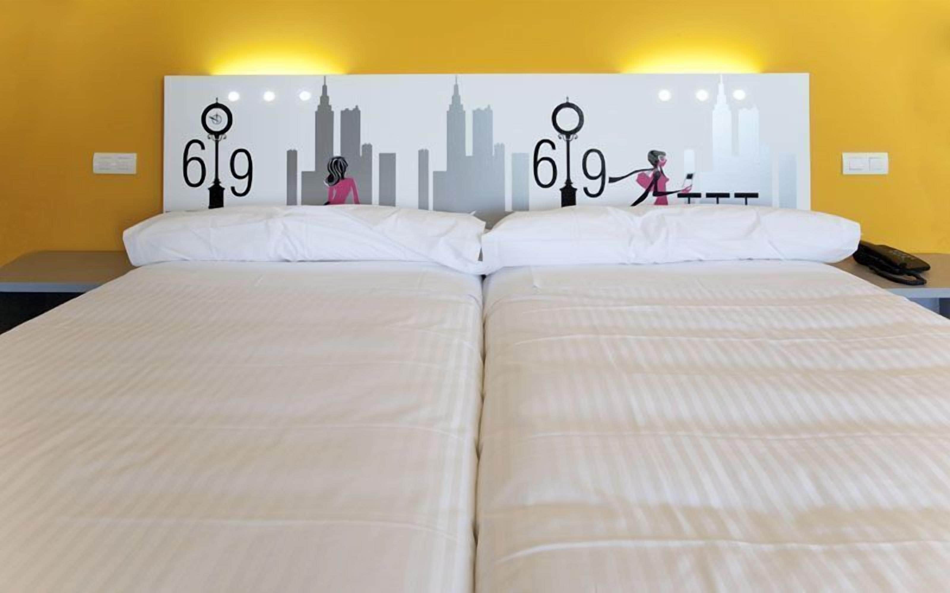 A double bed with a cityscape headboard featuring the numbers 619.