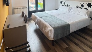 A hotel room with a bed, a desk, a chair, a chandelier, and a view of the outside. - Calas de Liencres (Pielagos)