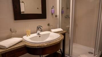 Ein Badezimmer mit Waschbecken, Spiegel und Dusche.