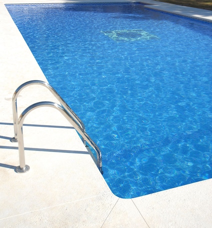 Una piscina al aire libre de temporada, sombrillas