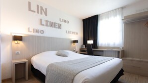 A hotel room with a large bed, bedside tables, a desk, and a window with curtains. - Hôtel Relais d'Etretat (Bolbec)