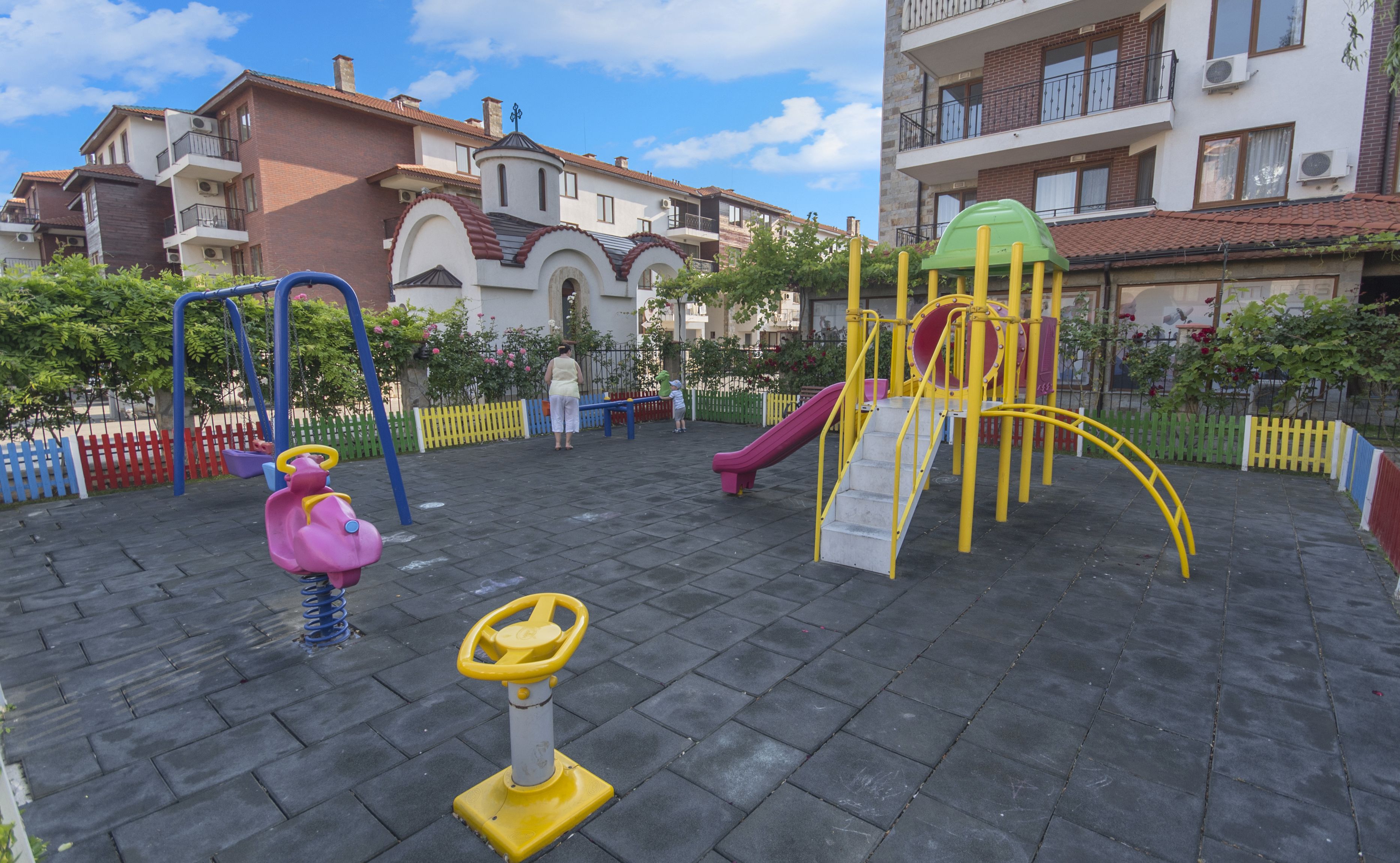 A playground with swings, a slide, and a climbing structure.