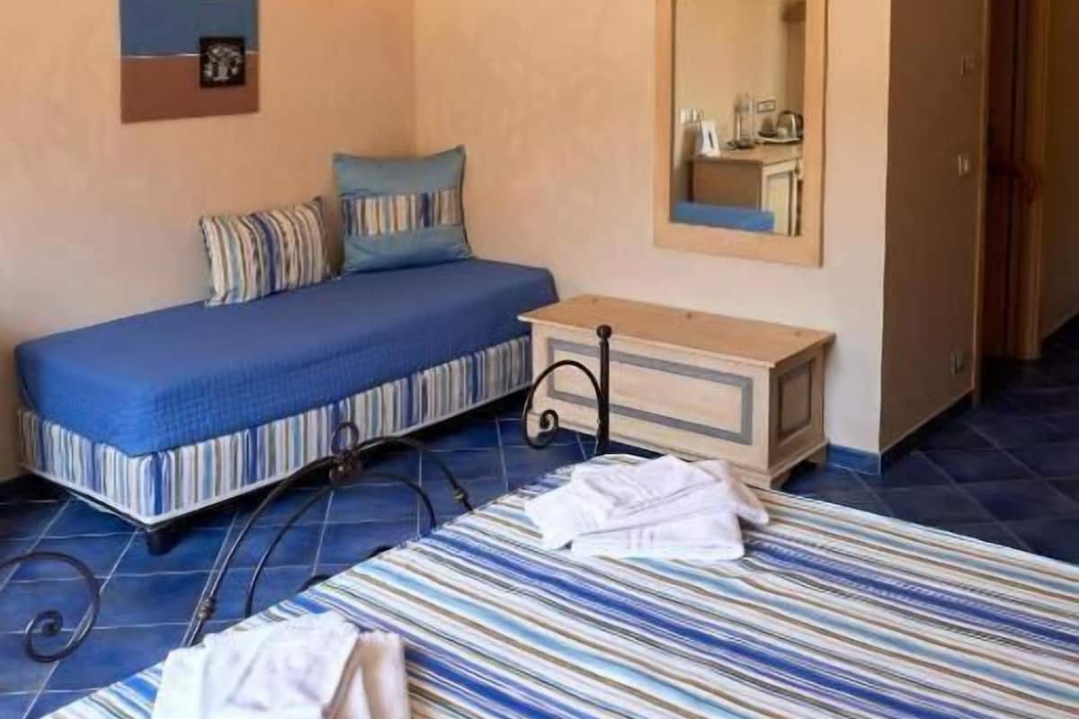 Un dormitorio con cama, mesita de noche y espejo.