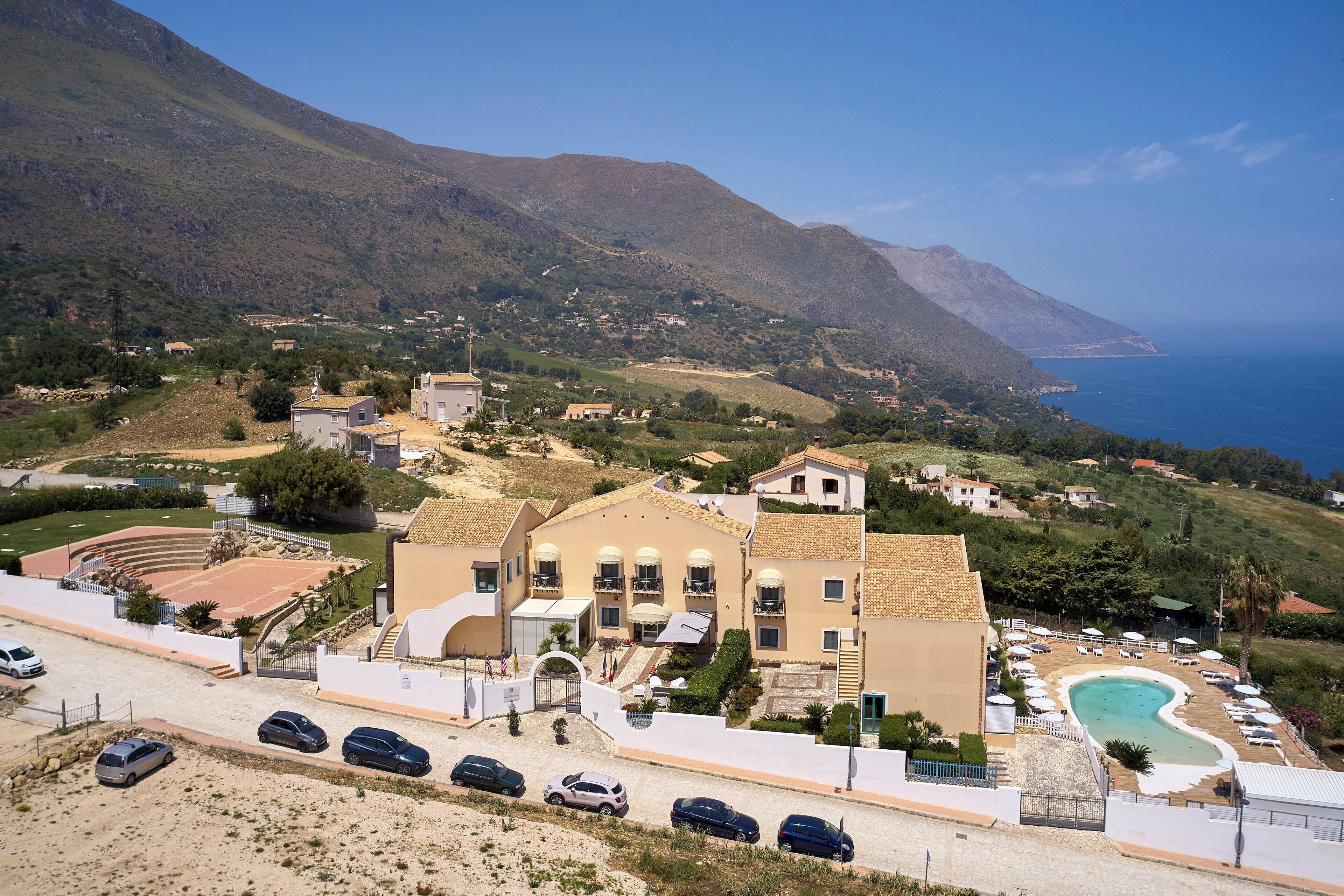 Un hôtel situé sur la côte, doté d’une piscine, d’un court de tennis et offrant une vue sur la mer.
