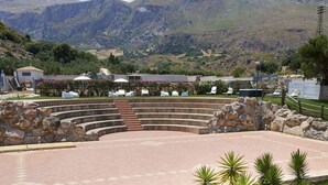 A landscaped outdoor area with a curved seating area, stone walls, and potted plants. - Baglio dello Zingaro (Castellammare del Golfo)