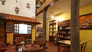 Un vestíbulo con muebles de madera, una estantería y un amplio ventanal.