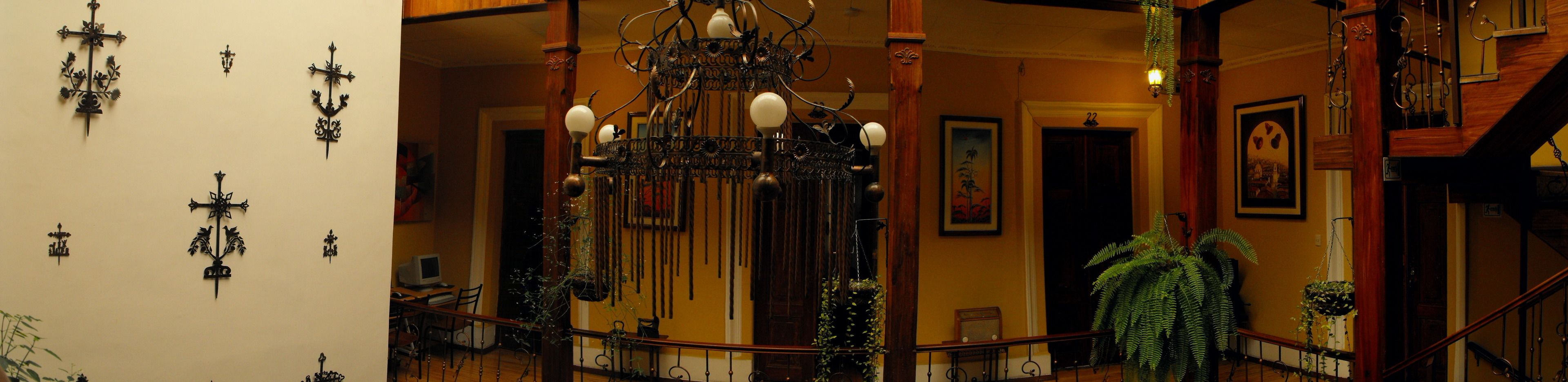 A staircase with a wooden railing, a chandelier, and several wall-mounted light fixtures.
