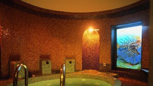 A circular hot tub with mosaic tile walls and a mural of a sea creature. - Hotel Odysseas (Kassandra)
