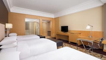 Una habitación de hotel con dos camas, un escritorio, un televisor y una lámpara.