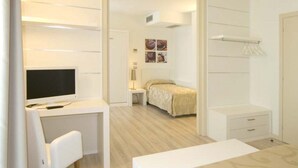 A bedroom with a bed, a desk, a chair, and a TV. - Hotel Vienna (Jesolo)
