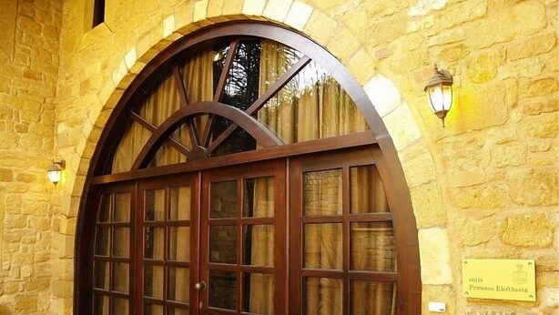 A stone building with a large wooden door and a sign that reads "suite Princess Eleftheria." - Palazzo Loupassi Villas (Platanias)