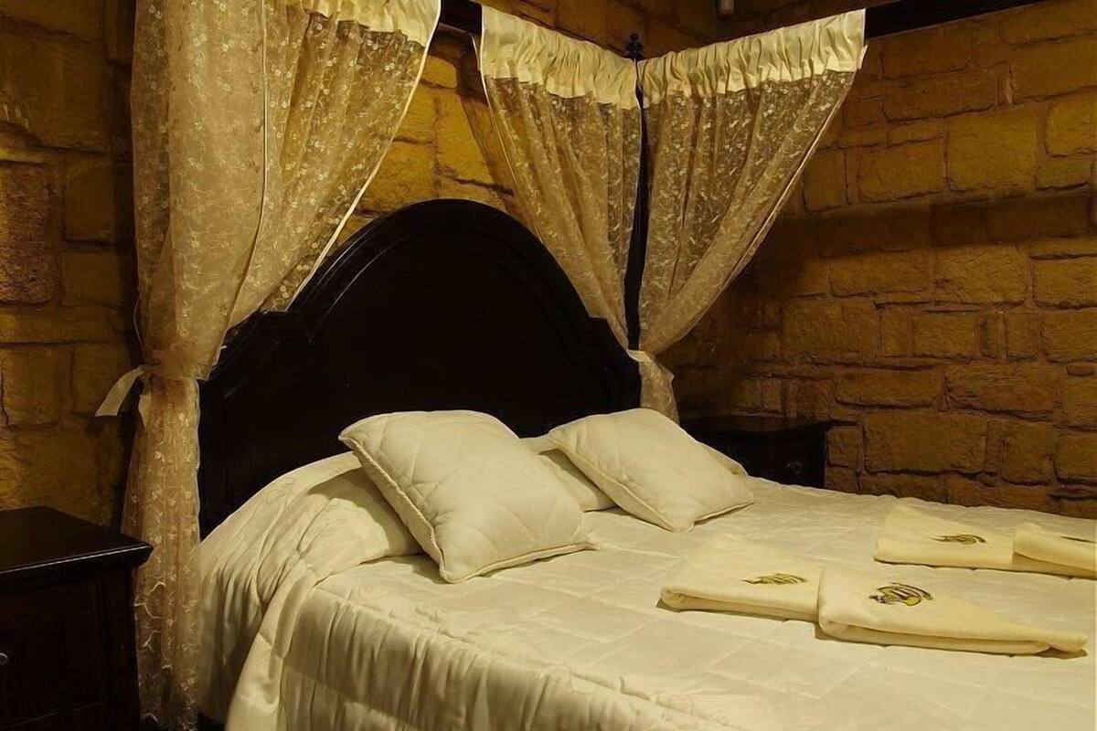 Un lit à baldaquin, avec une tête de lit et des oreillers.