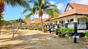 Um resort com vários edifícios no estilo de bangalôs, cada um com telhado de azulejos e varanda coberta.