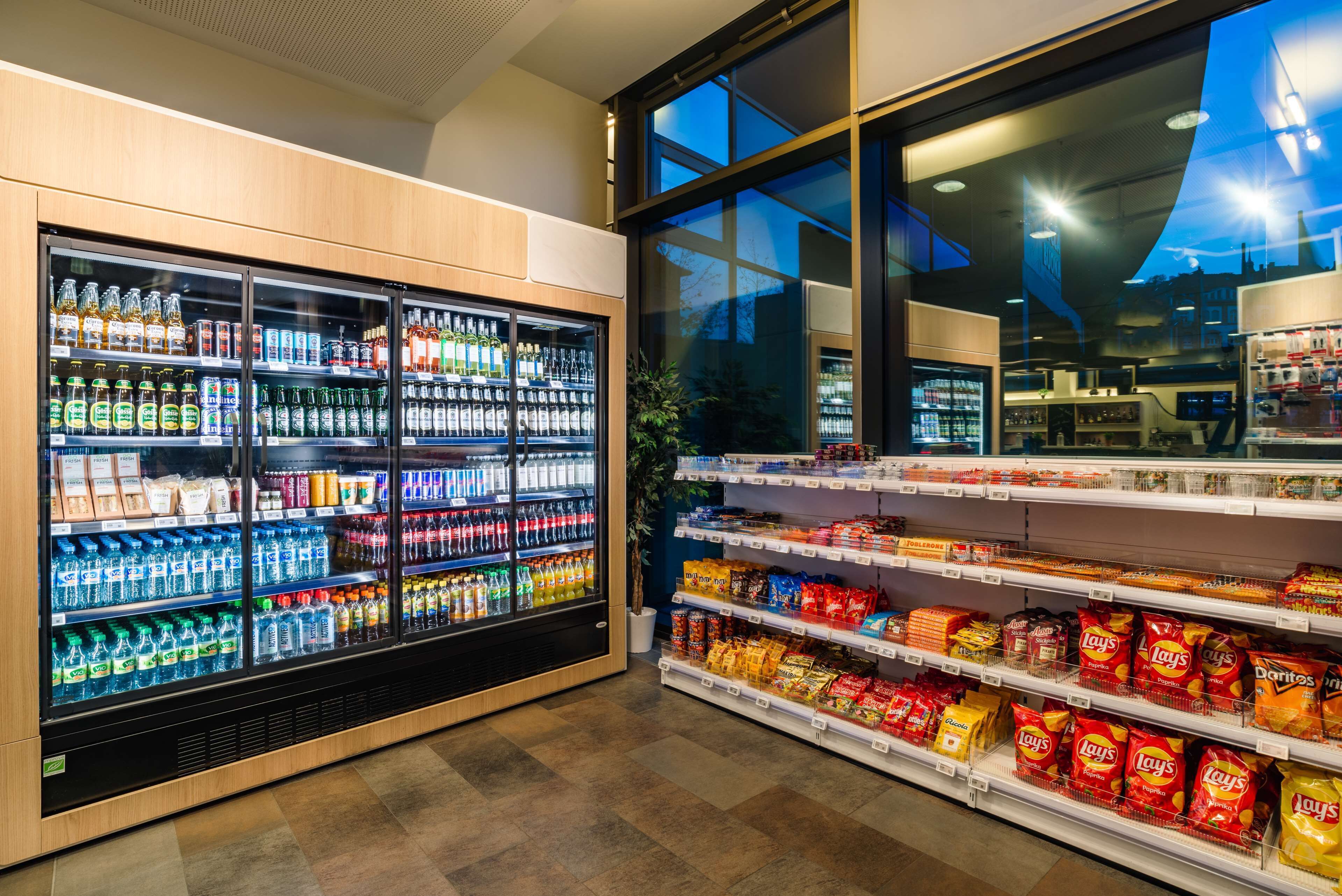 A refrigerated beverage display and snack shelves in a store.