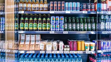 A refrigerated beverage display with various drinks including sodas, beers, and juices.