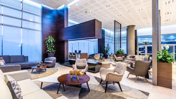 Relax in our spacious lobby with comfortable seating, potted plants, and a warm atmosphere.