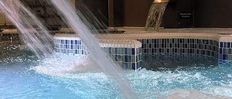 Un área de spa con una fuente de agua, una piscina con azulejos y un letrero que dice "ar spa".