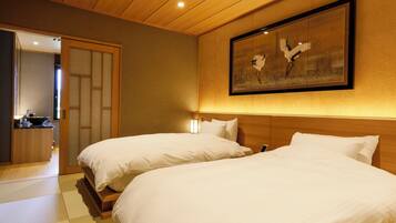 A hotel room with two beds, a wooden headboard, a framed artwork, and a traditional Japanese sliding door.