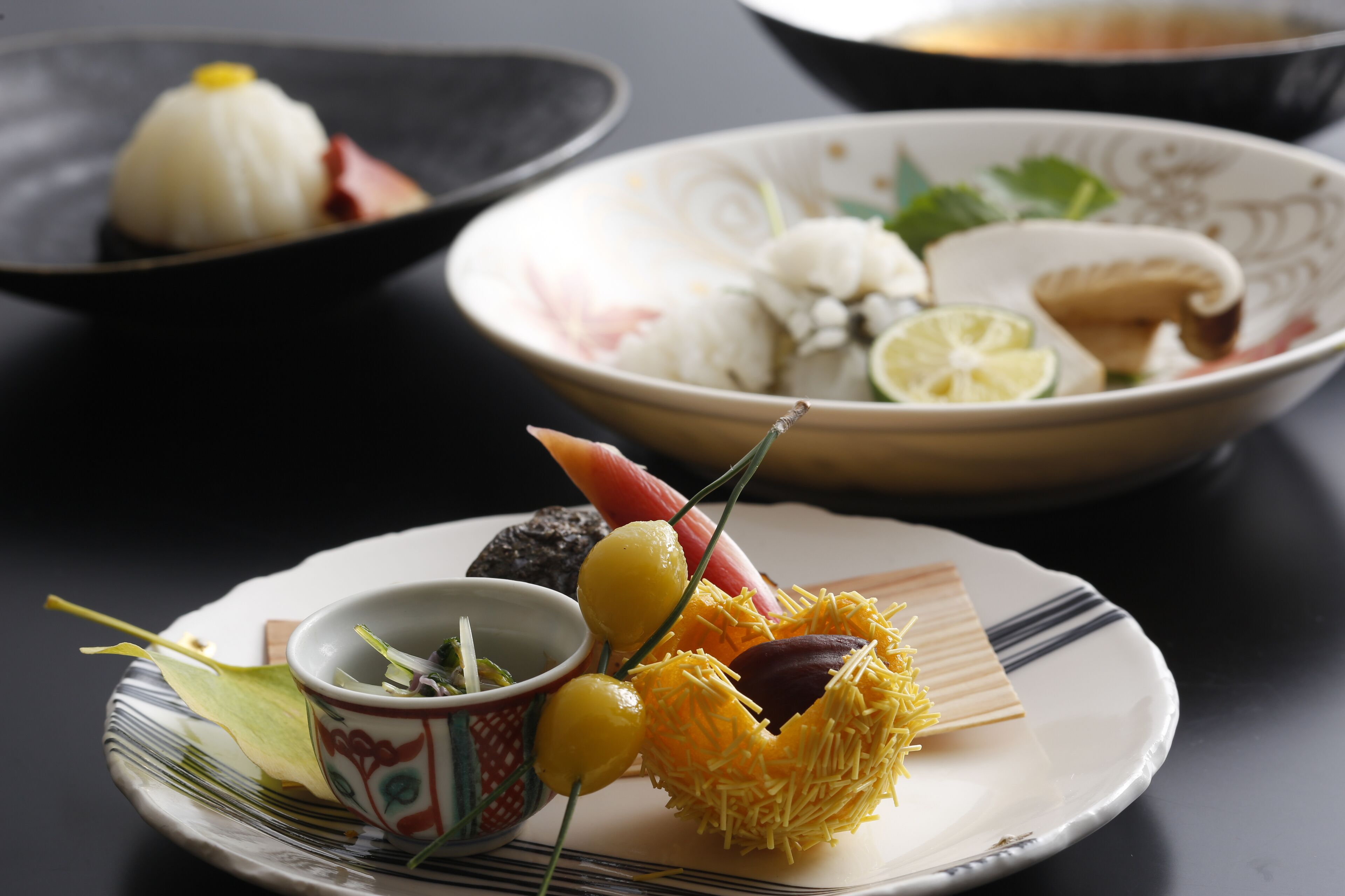 A table with three plates of food, each with different dishes and garnishes.