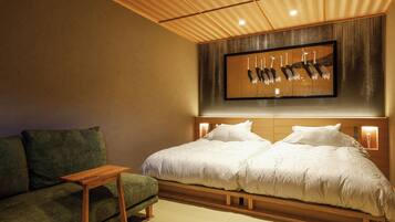 Un dormitorio con una cama, un sofá, una mesita y una obra de arte colgada en la pared.