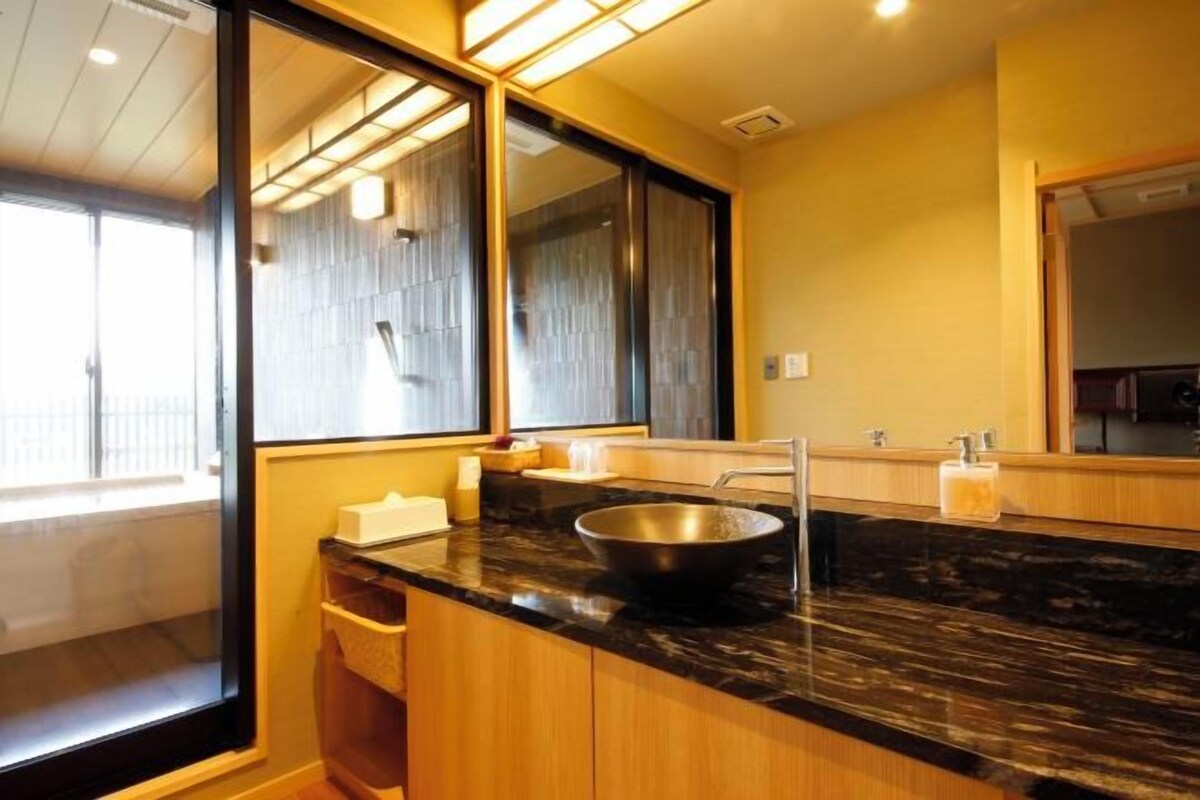 Una cocina moderna con encimera negra, pileta de acero inoxidable y armarios de madera.