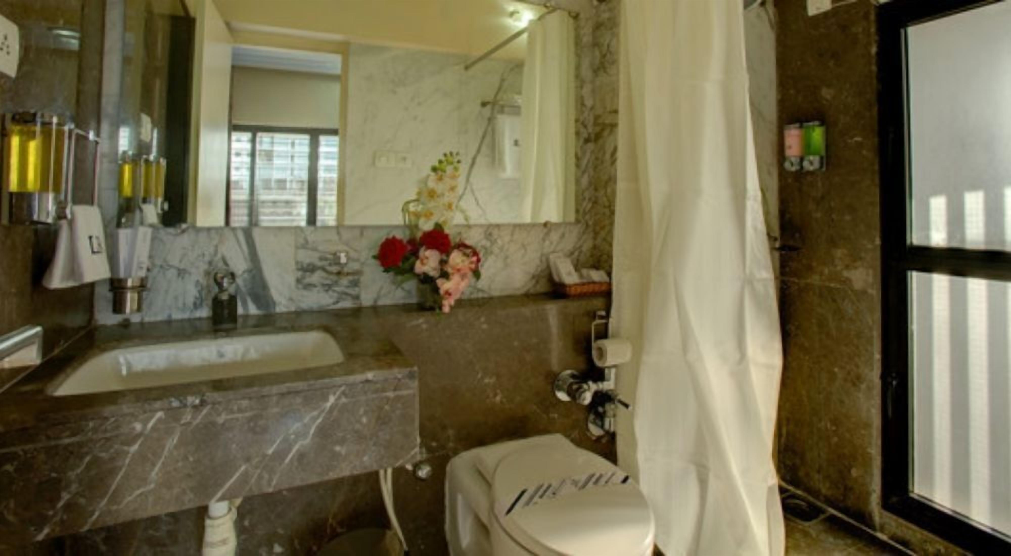 Un baño con lavabo de mármol, inodoro y ducha.