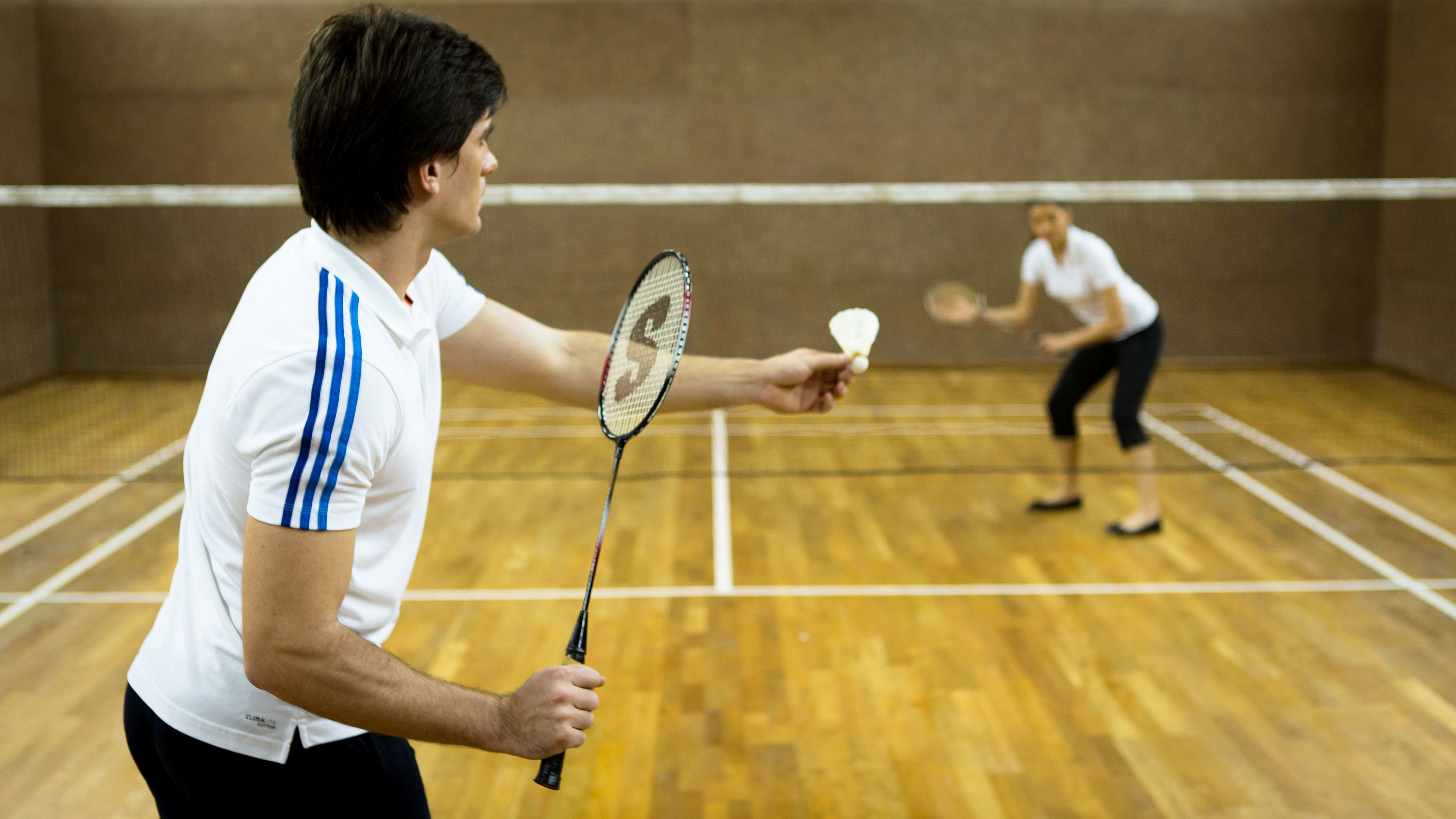 A badminton court with two players in action.