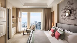 A hotel room with a large bed, a city view, a round mirror, and a small table with a chair. - The St. Regis Osaka (Osaka)