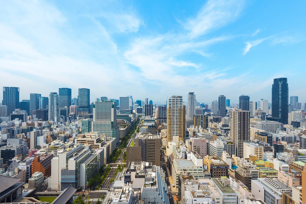 A cityscape with a variety of high-rise buildings, including a prominent skyscraper in the center.