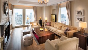 A spacious living room with a large window, a fireplace, a chandelier, and a city view. - The St. Regis Osaka (Osaka)