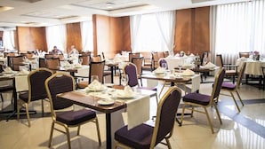 Un comedor amplio con varias mesas y sillas, dispuestas en un patrón de cuadrícula.
