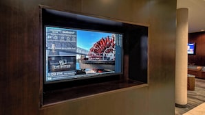 A digital display in a hotel lobby with a large screen showing a weather forecast, a restaurant menu, and a timestamp. - Courtyard by Marriott Alexandria (Alexandria)