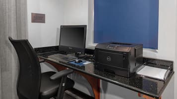 Escritorio de biblioteca para negocios con computadora, impresora y silla.