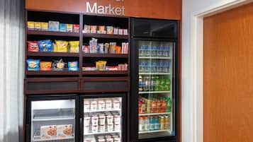 Un mercado de barrio con estantes llenos de bocadillos, bebidas y alimentos envasados.