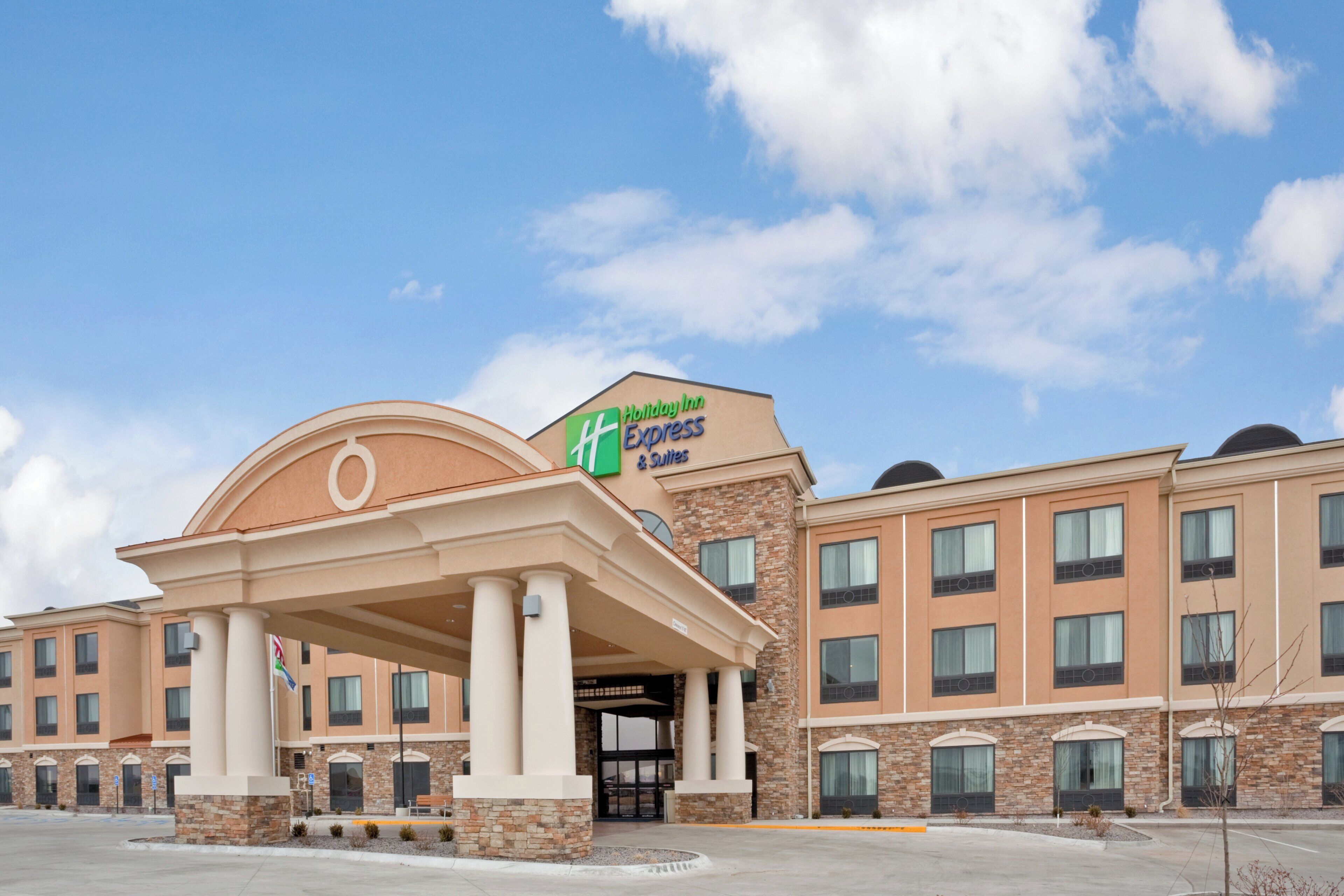 A Holiday Inn Express hotel with a prominent entrance, multiple windows, and a clear sky.