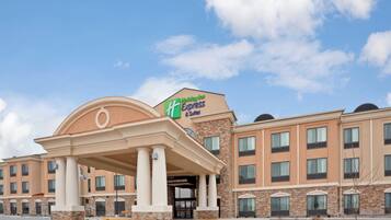 A Holiday Inn Express hotel with a prominent entrance, multiple windows, and a clear sky.