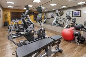 A gym with various exercise equipment, including treadmills, elliptical machines, and a stationary bike. - Holiday Inn Express Hotel & Suites Hays by IHG (Hays)