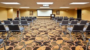 A conference room with rows of chairs, a projector screen, and a carpeted floor. - Holiday Inn Express Hotel & Suites Great Falls by IHG (Great Falls)