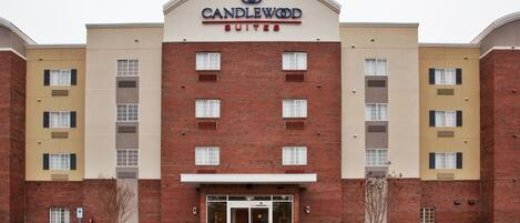 Een gebouw van baksteen met een bord waarop 'CANDLEWOOD SUITES' staat en het nummer '1095' op de ingang.